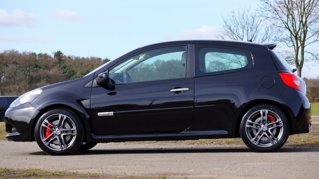 gros plan sur le flanc d'un pneu de Renault Clio 2 montrant les inscriptions dimensionnelles gravées, lumière naturelle d'un atelier